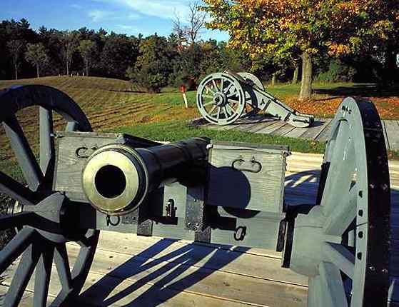 Antique cannon on display at a historical battlefield park, surrounded by the vibrant hues of autumn.